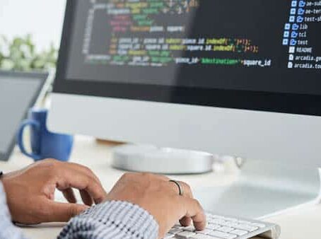 A man working on a computer with code on the screen