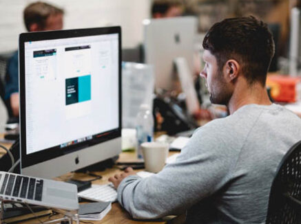 A man sitting at a desk working on a computer