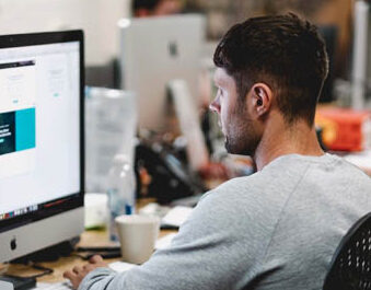 A man sitting at a desk working on a computer